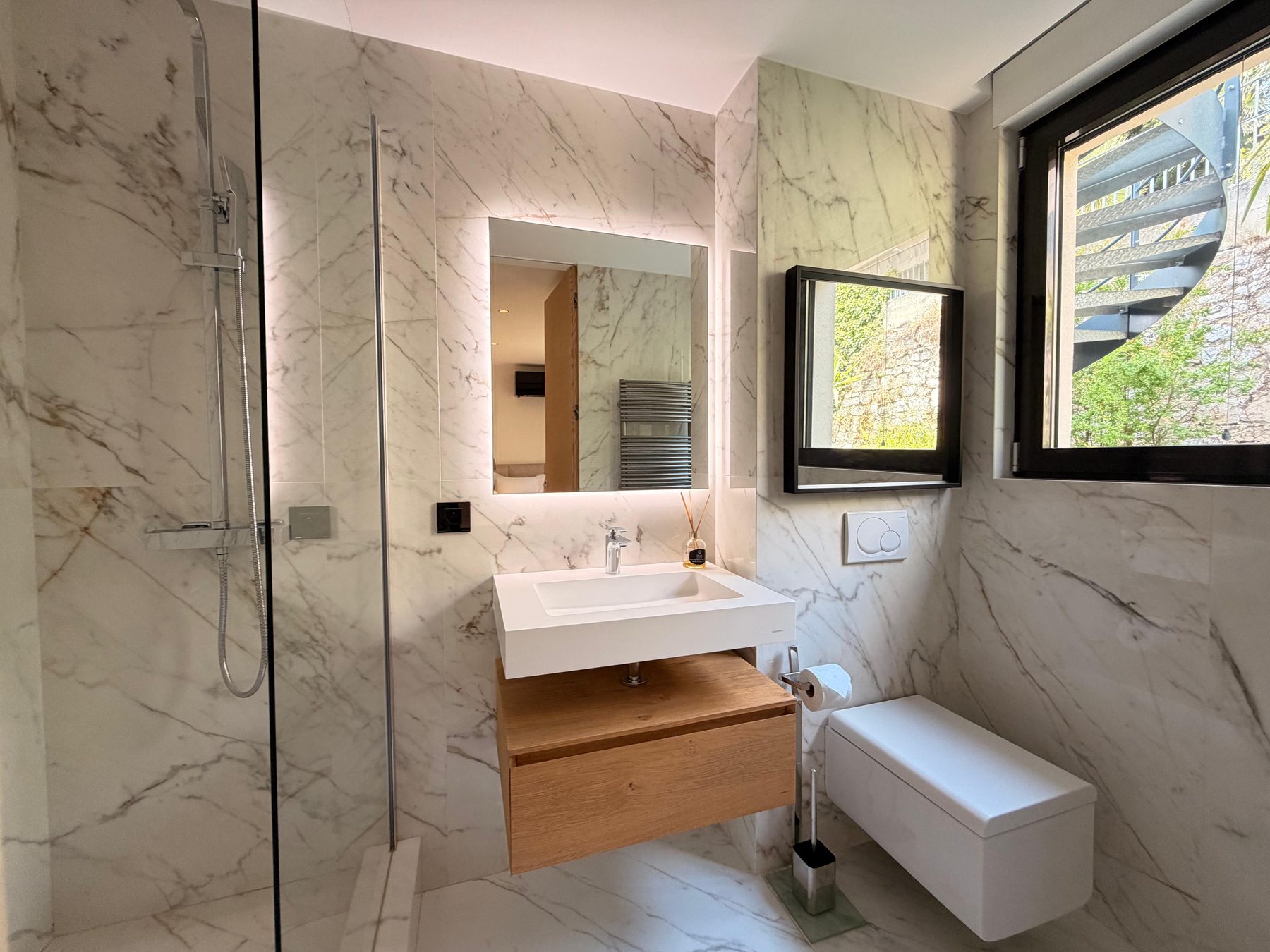 Marble en-suite bathroom with a floating oak vanity