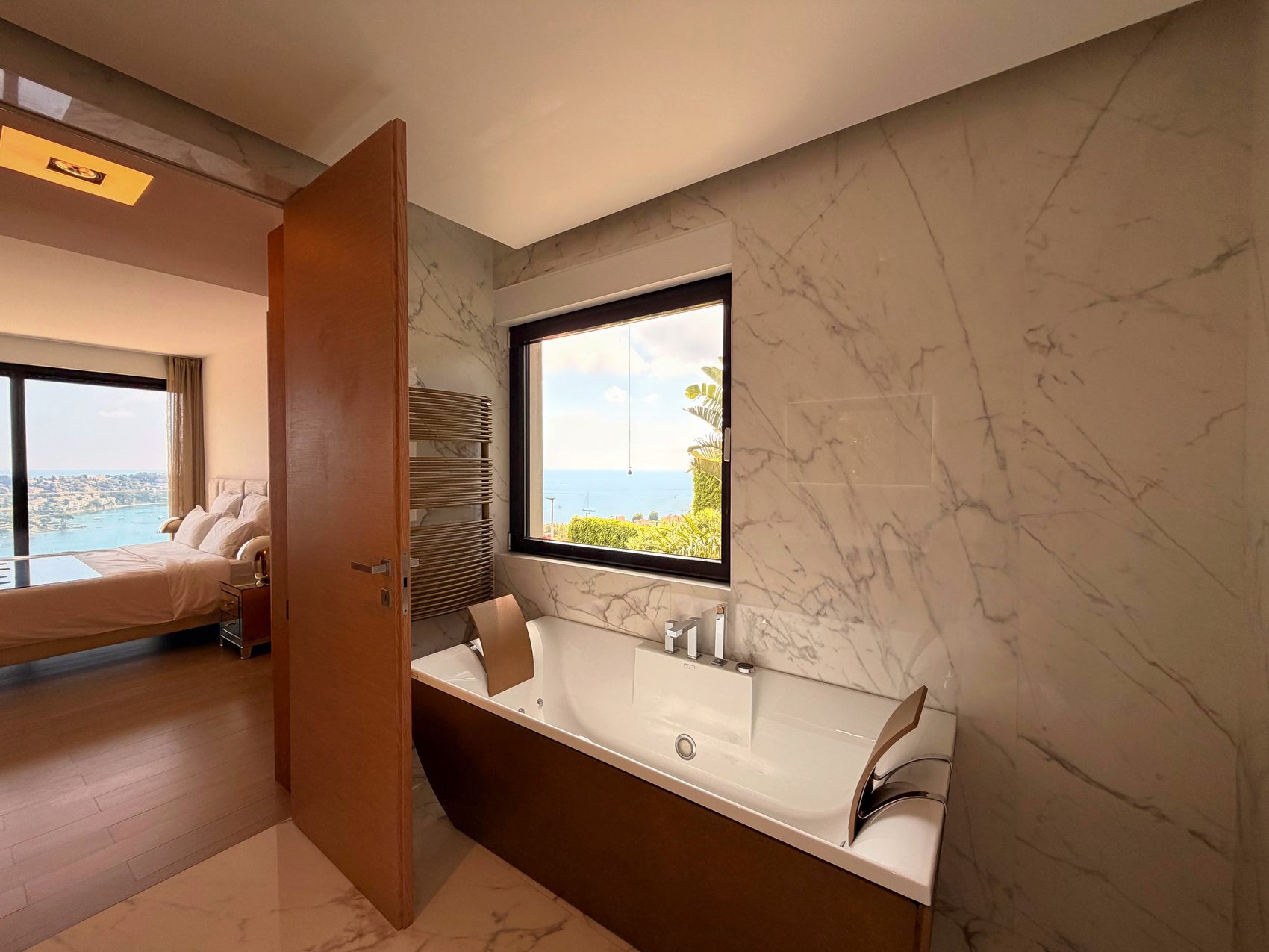 En-suite bath with the bedroom and the sea beyond