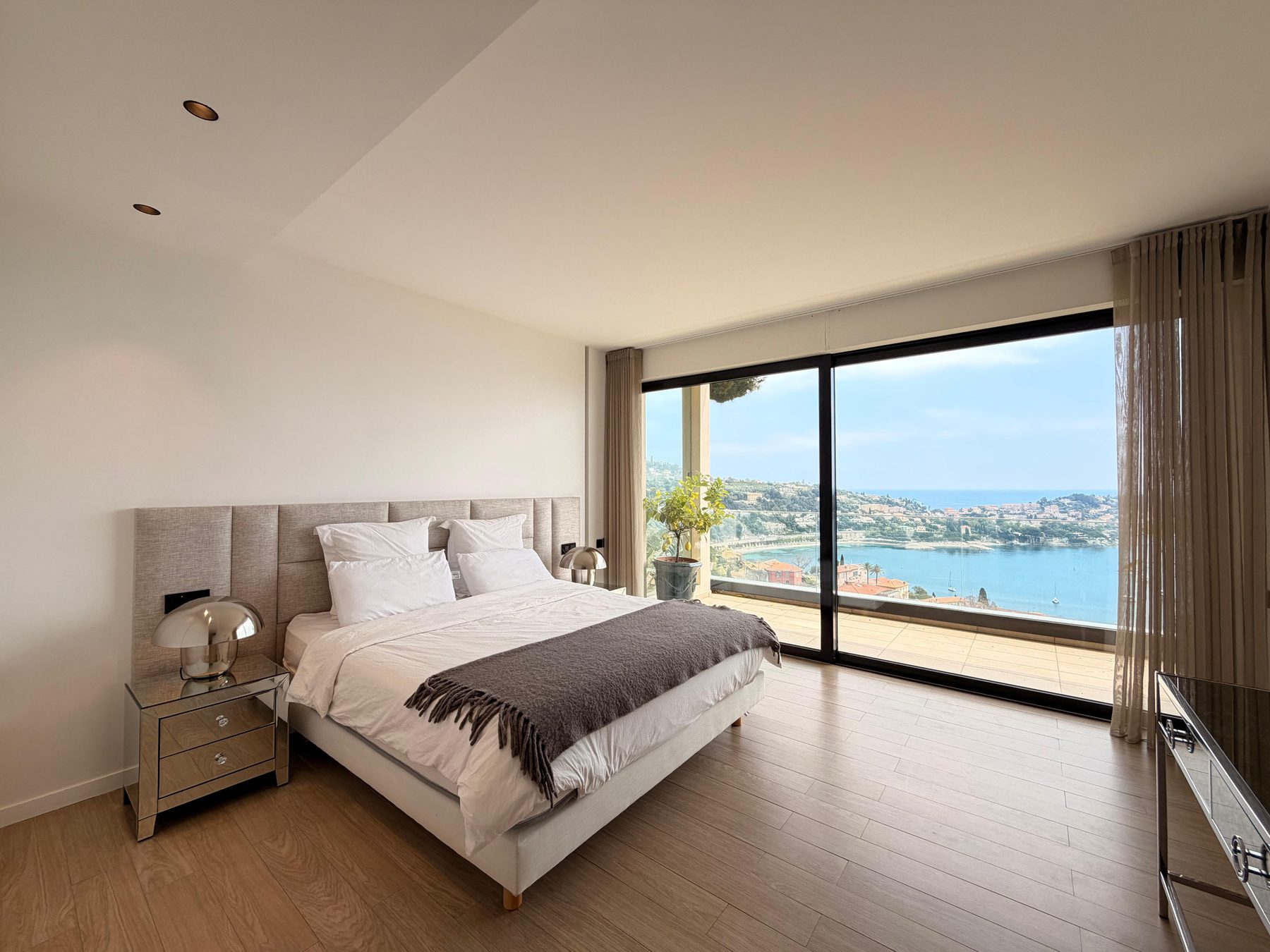 Principal double bedroom with a wall of glass framing the sea