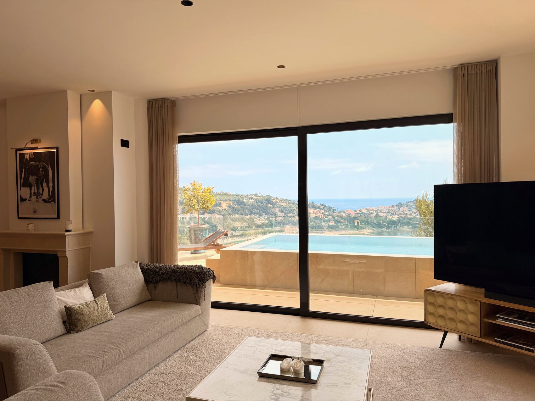 Salon beside the fireplace with a sea view through full-height glass